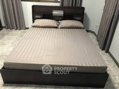 Spacious bedroom with modern bed and stylish curtains, perfect for restful nights.
