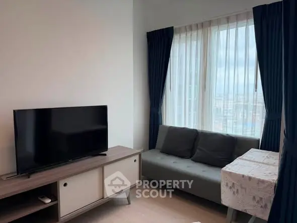 Modern living room with TV, sofa, and large window with city view.