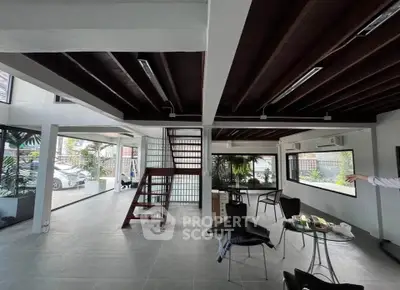 Spacious modern living area with open layout and large windows offering natural light and garden views.