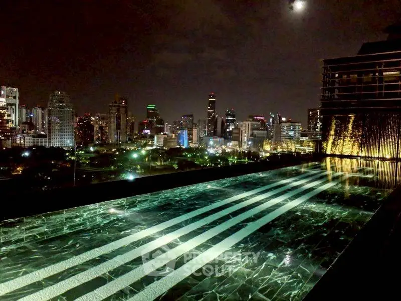 Luxurious rooftop pool with stunning city skyline view at night, perfect for urban living.