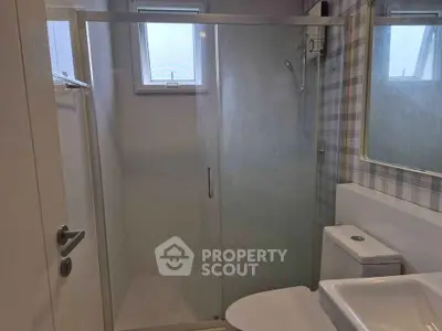 Modern bathroom with glass shower enclosure and stylish fixtures.