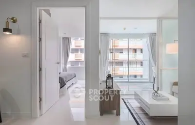 Modern apartment interior with open living room and bedroom, featuring sleek design and large windows.
