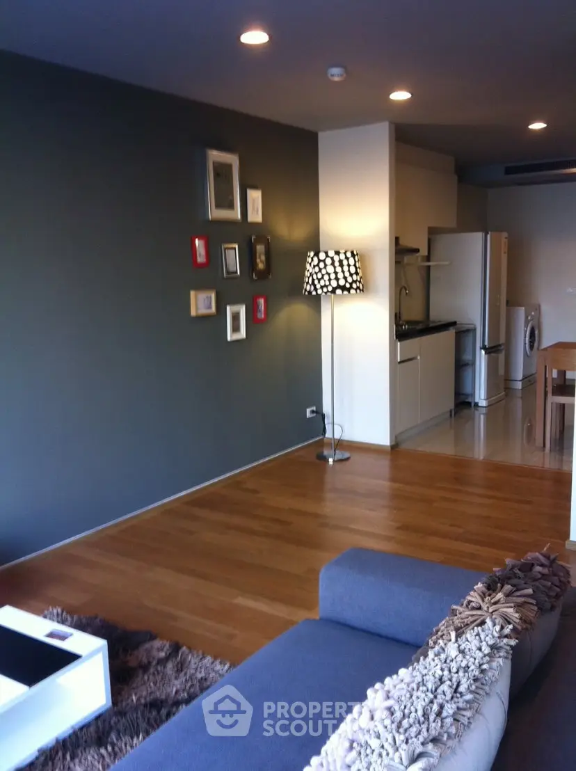 Modern living room with stylish decor and open kitchen layout in a cozy apartment.