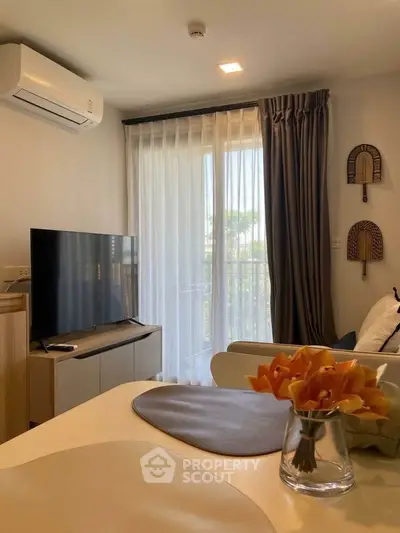 Modern living room with large TV, air conditioning, and elegant decor in a cozy apartment.