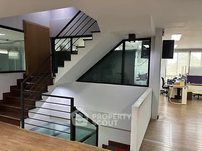 Modern office interior with sleek staircase and open workspace design