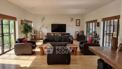 Spacious living room with modern leather sofas and large windows for natural light