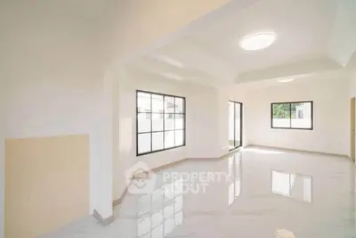 Spacious modern living room with large windows and glossy floors