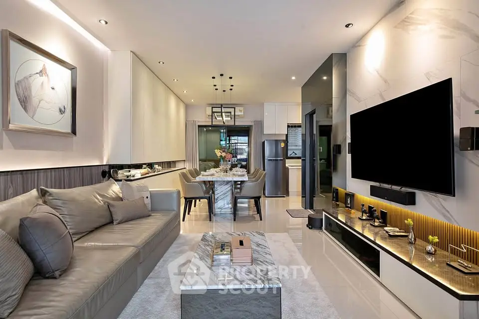 Luxurious modern living room with elegant decor and open dining area, featuring sleek furniture and ambient lighting.