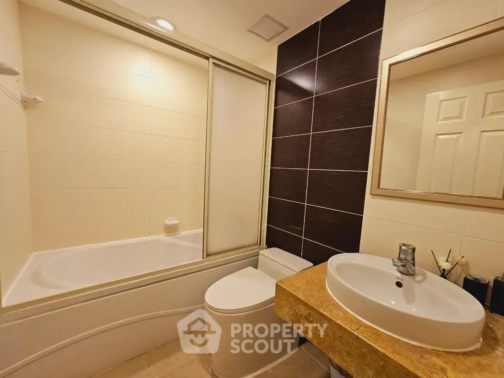 Modern bathroom with sleek design featuring a bathtub and stylish sink area.