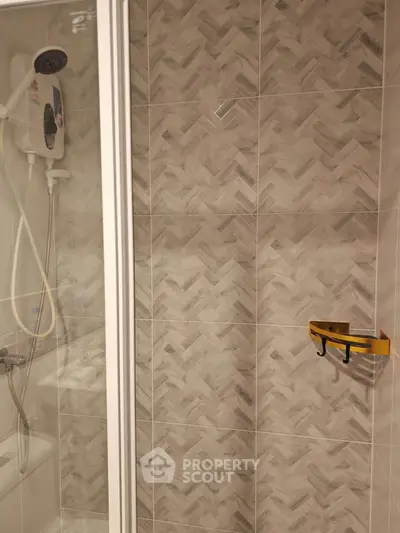 Modern bathroom with stylish herringbone tile design and shower area