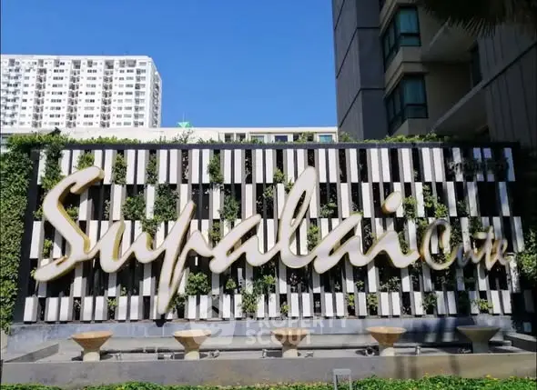 Modern building facade with stylish Supalai signage and lush greenery