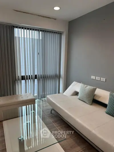 Modern living room with sleek white sofa and glass coffee table