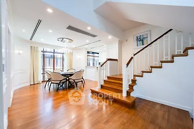 Luxurious open-plan living area with elegant staircase and dining space