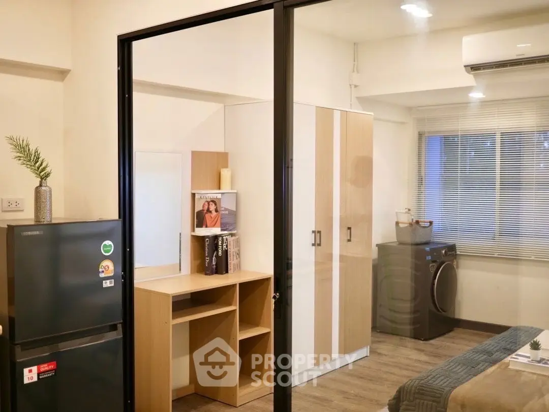 Modern apartment interior with sleek furniture and appliances, featuring a compact living space.