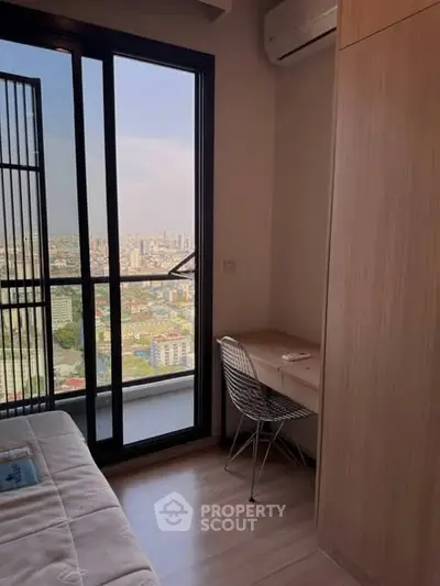 Modern bedroom with city view and balcony access, featuring sleek furniture and natural light.
