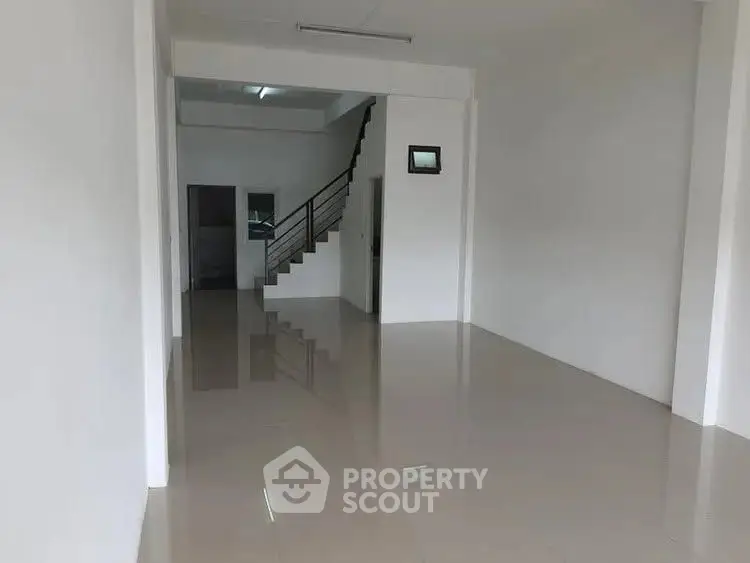 Spacious open-plan interior with sleek tiled flooring and modern staircase, ideal for customization.