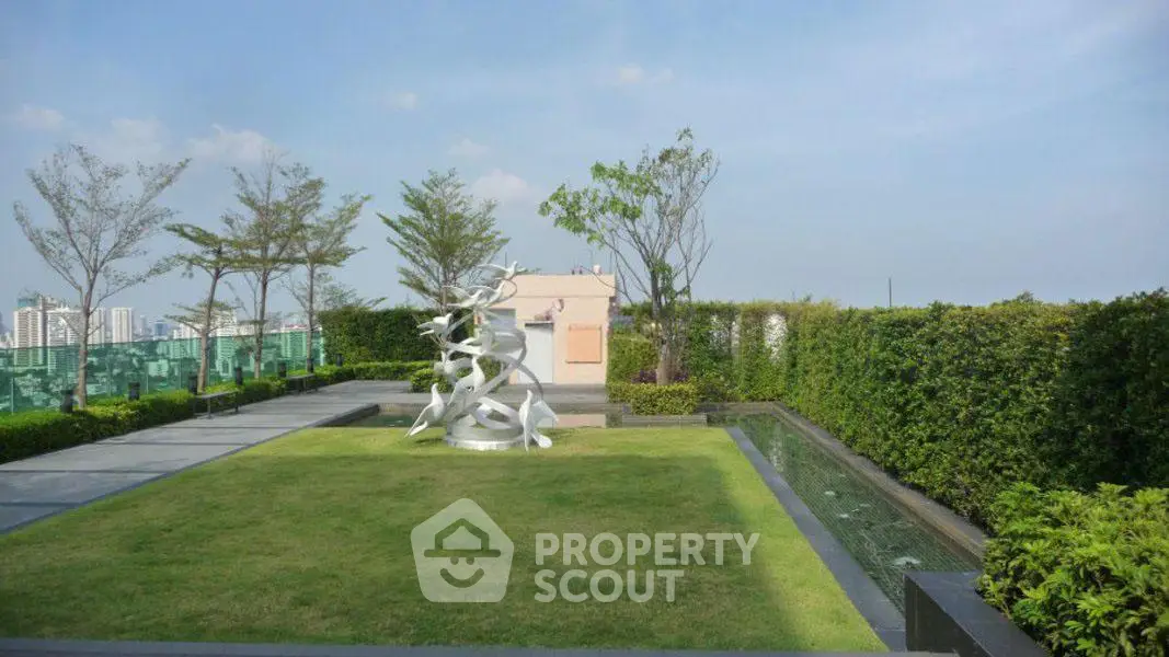 Luxurious rooftop garden with modern sculpture and stunning city views.