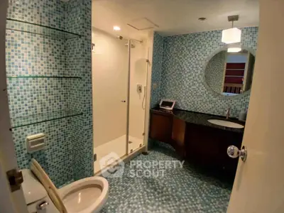 Modern bathroom with mosaic tiles and glass shower enclosure
