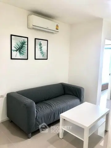 Modern living room with sleek gray sofa, white coffee table, and minimalist decor.