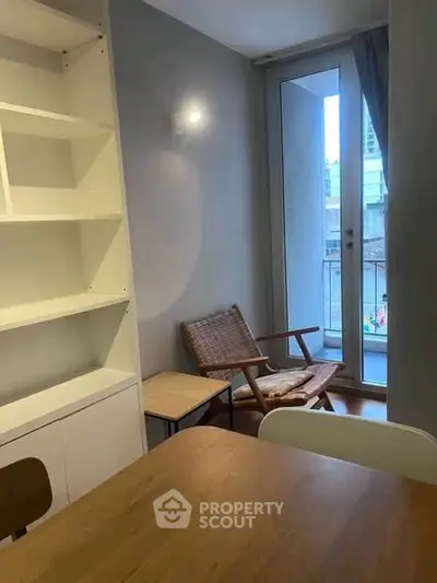 Cozy interior with modern furniture and small balcony access, perfect for urban living.