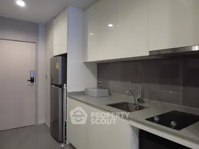 Modern kitchen with sleek cabinetry and stainless steel appliances in a contemporary apartment.