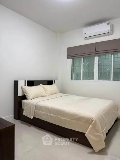 Modern bedroom with air conditioning and minimalist decor, perfect for a cozy and comfortable living space.
