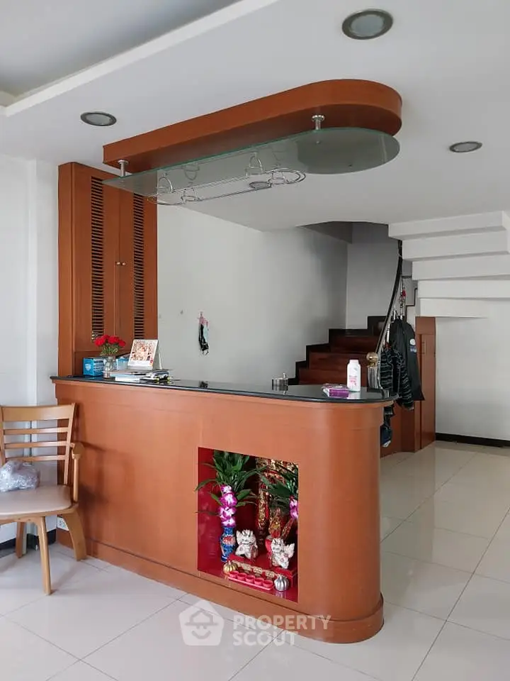 Modern interior with stylish wooden counter and staircase in a cozy living space.