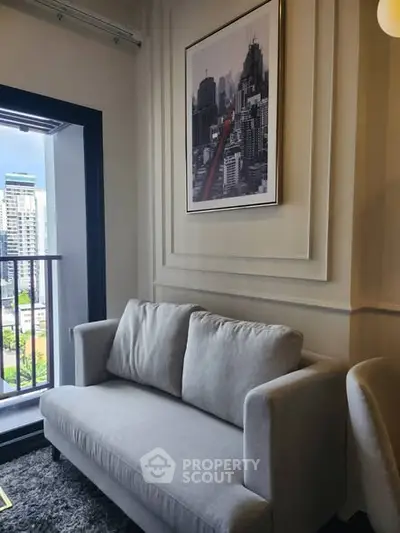 Modern living room with cozy sofa and cityscape artwork near balcony view.