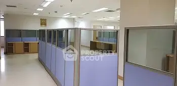 Spacious office space with modern cubicles and ample natural light, perfect for a productive work environment.