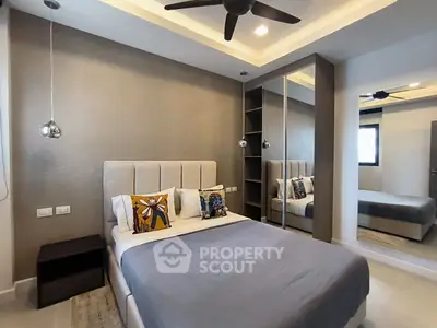 Modern bedroom with stylish decor and mirrored wardrobe in a contemporary apartment.