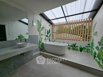 Luxurious bathroom with modern bathtub and skylight, featuring elegant plant-themed decor.