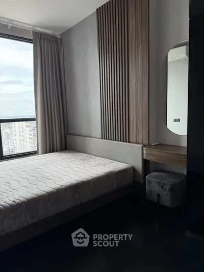 Modern bedroom with city view, featuring stylish wood paneling and elegant furnishings.