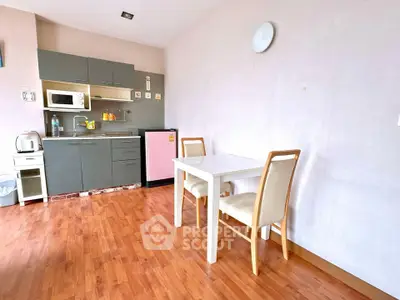 Cozy kitchen with dining area, featuring modern appliances and wooden flooring.
