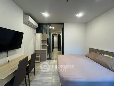 Modern bedroom with sleek design and spacious layout, featuring a large bed and wall-mounted TV.