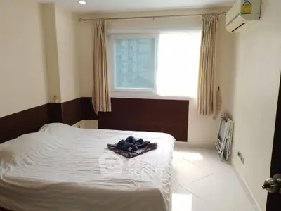 Cozy bedroom with natural light and air conditioning in modern apartment.