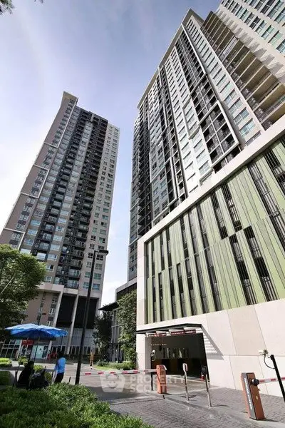 Modern high-rise residential buildings with lush greenery and secure entrance.