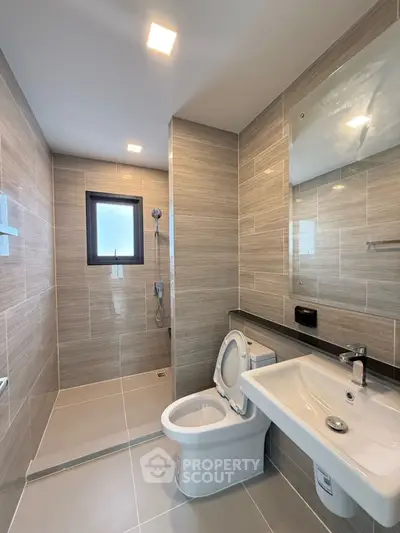 Modern bathroom with sleek design, featuring a walk-in shower and contemporary fixtures.