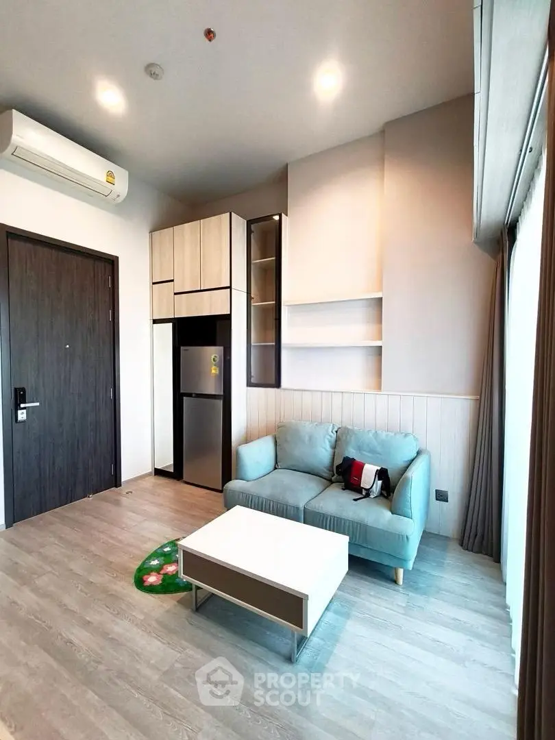 Modern living room with sleek furniture and natural light, featuring a cozy sofa and stylish shelving.