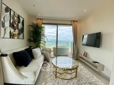 Luxurious living room with ocean view and elegant decor, featuring a cozy sofa and wall-mounted TV.