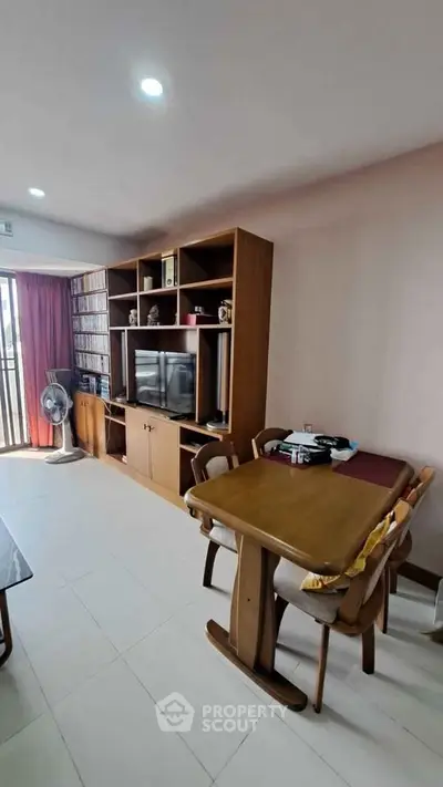 Cozy living room with wooden furniture and entertainment center, perfect for relaxation.