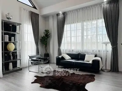 Elegant living room with modern decor, large windows, and stylish furniture, perfect for luxury living.