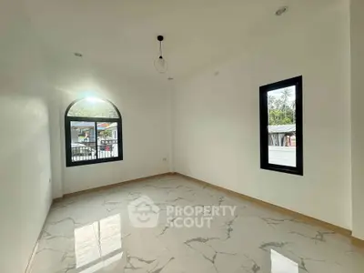 Bright and spacious room with large windows and elegant marble flooring, perfect for modern living.
