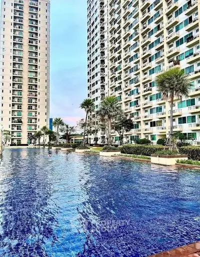 Luxurious high-rise apartment complex with stunning pool and landscaped surroundings.