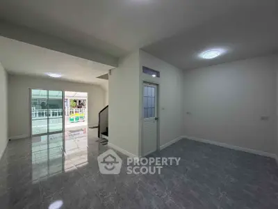 Spacious modern living room with sleek tile flooring and abundant natural light.