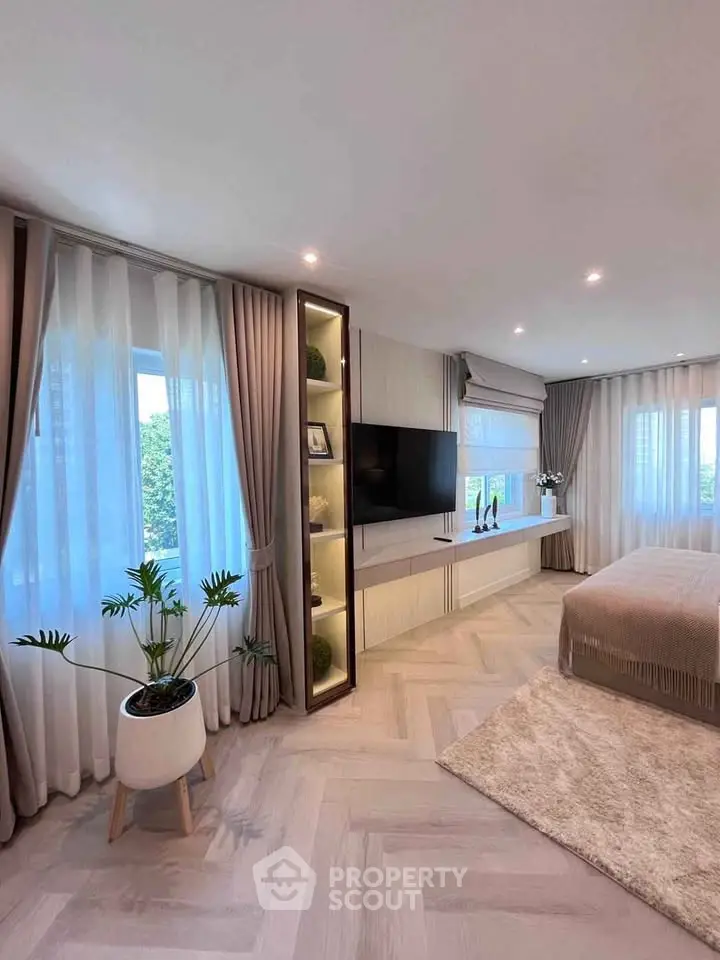 Luxurious bedroom with modern decor, large windows, and elegant furnishings.