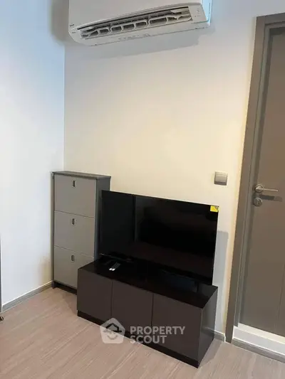 Modern living room corner with sleek TV stand and air conditioning unit.
