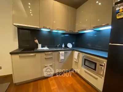 Modern kitchen with sleek cabinets and built-in microwave in stylish apartment.