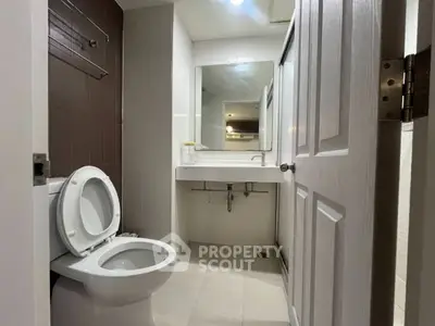 Modern bathroom with sleek fixtures and large mirror in a contemporary home.