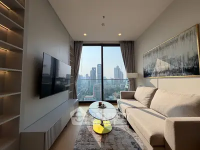 Modern living room with city view, stylish furniture, and large windows in a high-rise apartment.