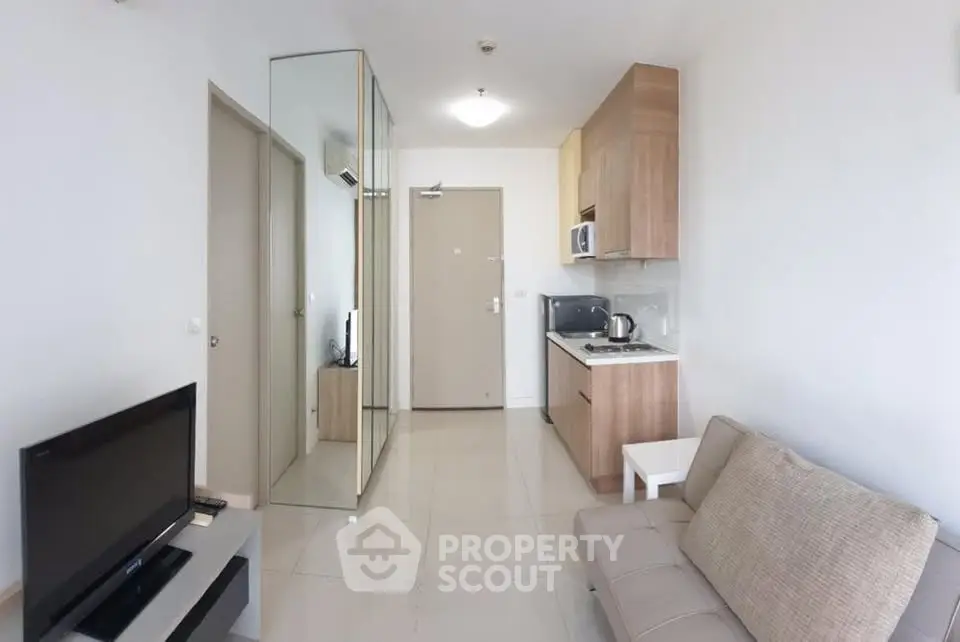 Modern apartment living room with sleek kitchen and mirrored storage